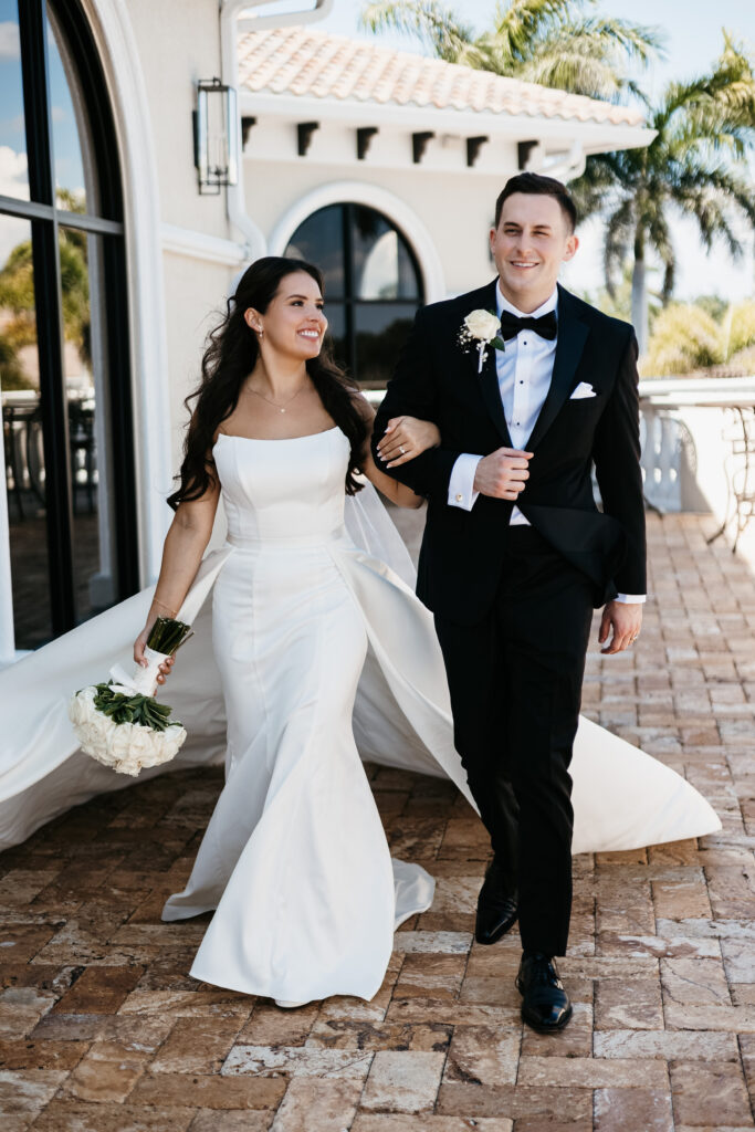 Bride and groom happily walk together after their wedding ceremony at Heritage Bay Golf and Country Club in Naples, Florida. 