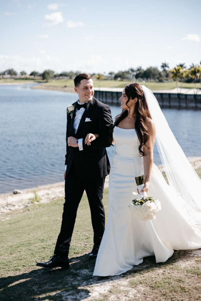 Bride and groom walk by the lake after their wedding at Heritage Bay Golf and Country Club in Naples, Florida. 