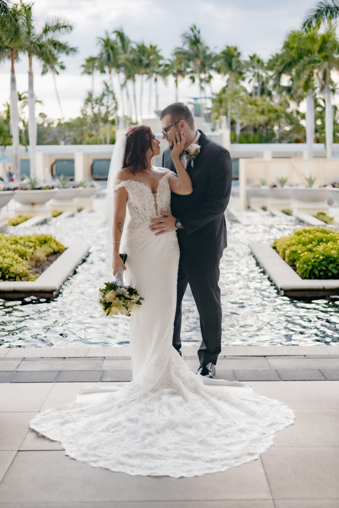 Bride and groom pose in front of a beautiful mosaic fountain during their wedding at the Hyatt Regency Coconut Point in Estero, Florida. 