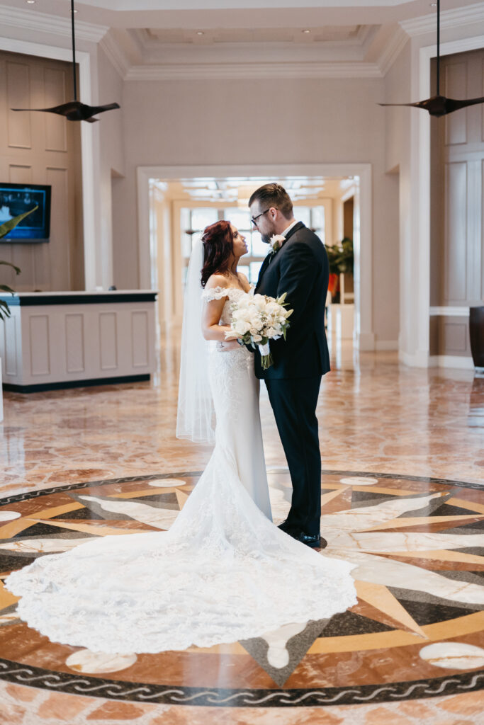 Bride and groom pose in the hotel lobby during their wedding at the Hyatt Regency Coconut Point in Estero, Florida. 