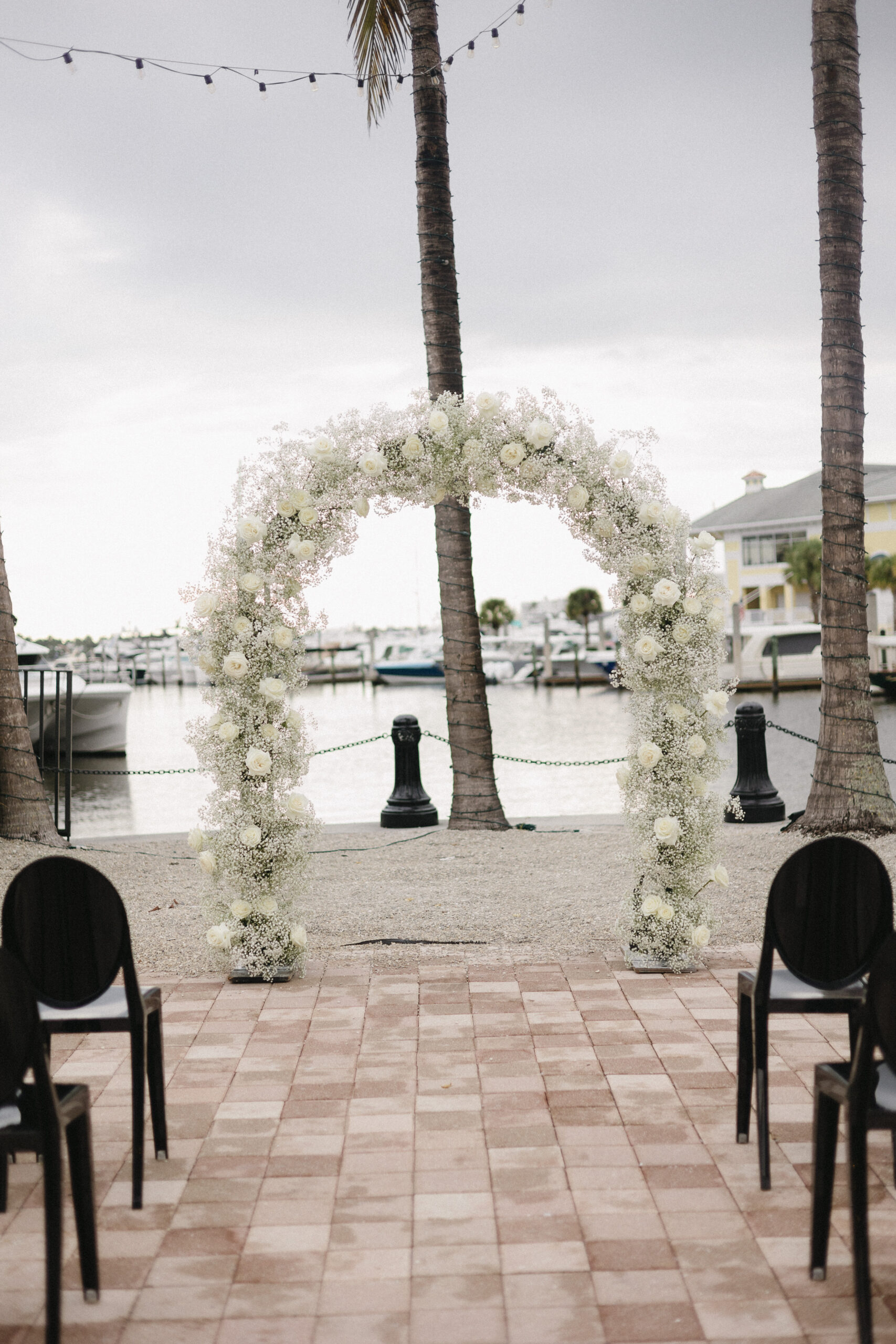 Naples Bay Resort wedding arch with white florals overlooking the bay